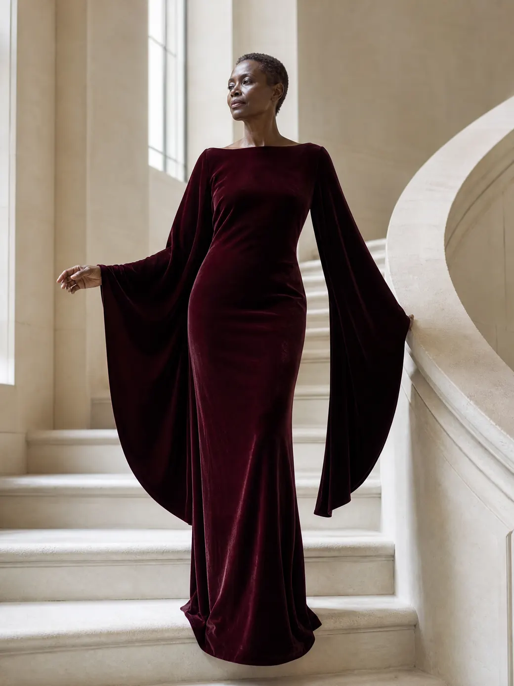 Vestido largo de terciopelo burdeos en una escalera de piedra clara