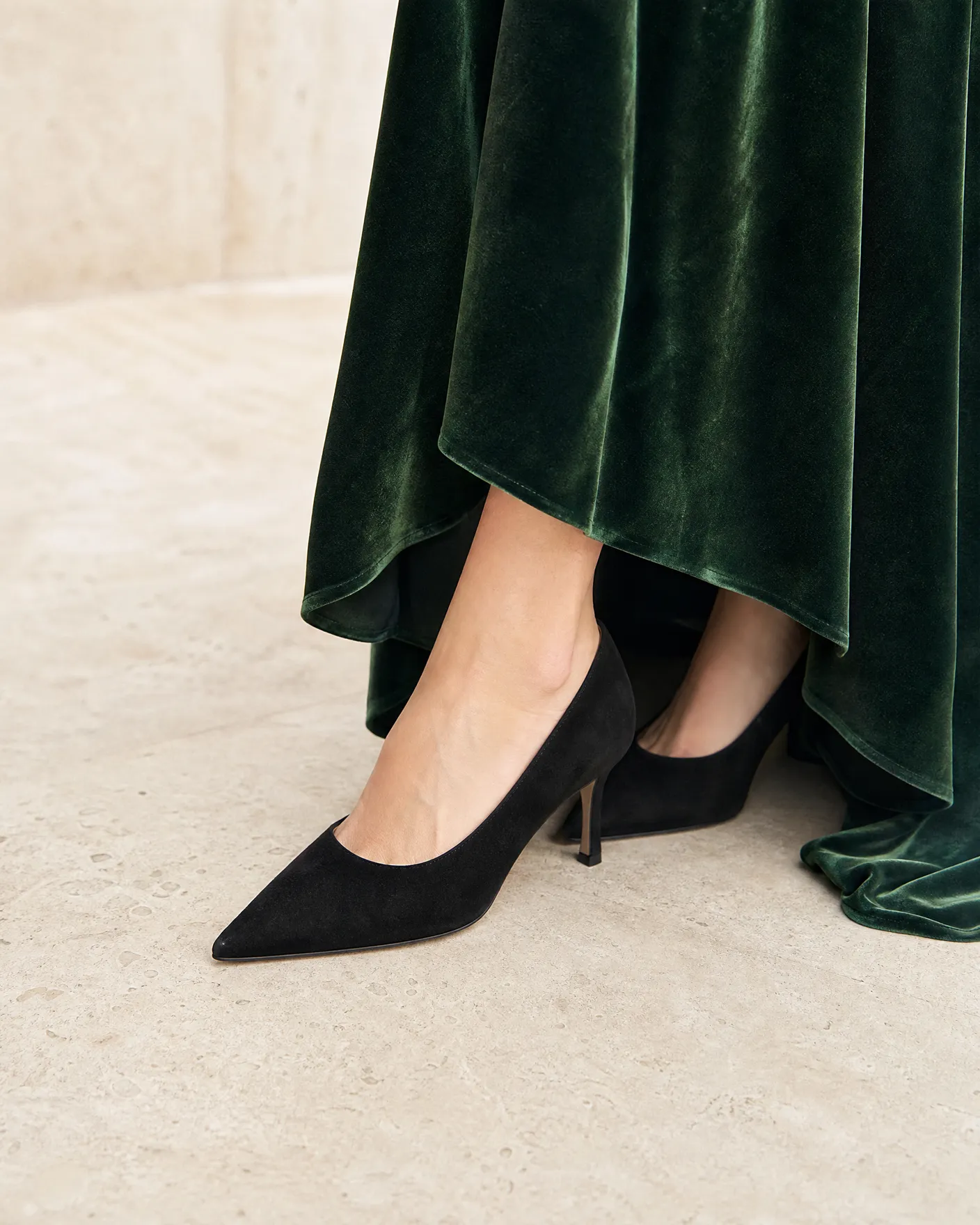 Illustration: a black suede stiletto beneath the hem of a dark green velvet gown